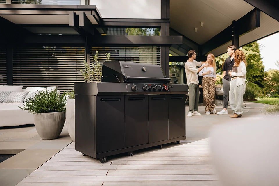 Enders Uniq 4 IK Kitchen steht auf der Terrasse mit 2 Pärchen im Hintergrund