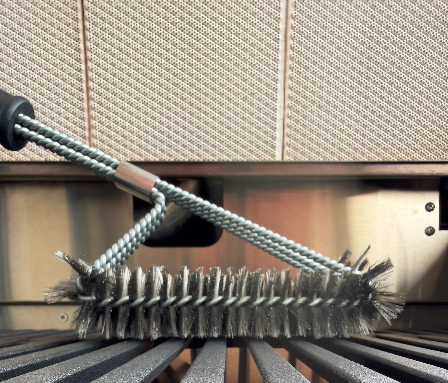 Grillbürste im Grill von der Seite