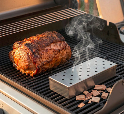 Smokerbox auf einem Gasgrill neben einen Braten